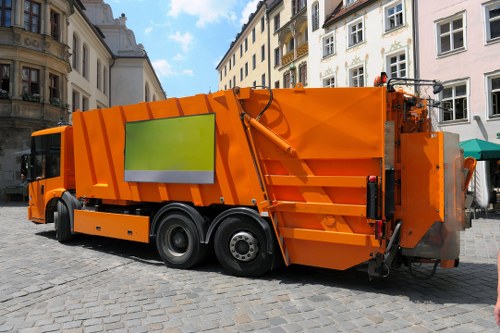 Worker placing a skip outside a semi-detached home in Morden